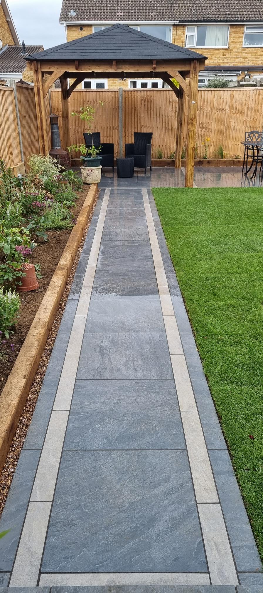 Beautifully landscaped garden with curved path and wooden gazebo by Cornerstone